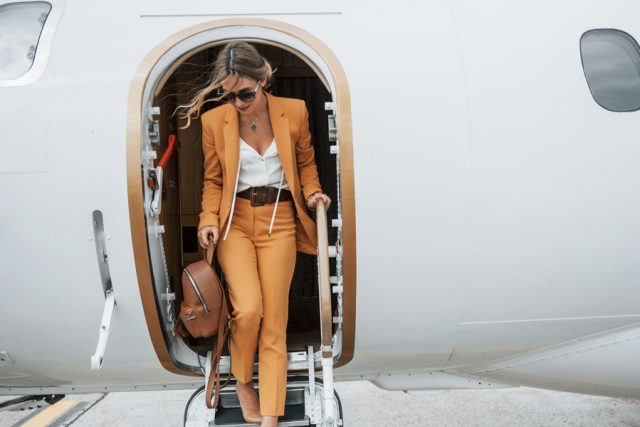 Smart dress lady stepping out of private jet.