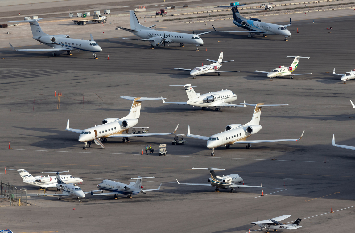 There are several private jets of different sizes on the tarmac.
