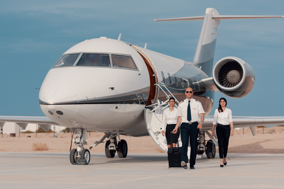 Flight attendant or crew walking, pulling a suitcase in front of an aircraft